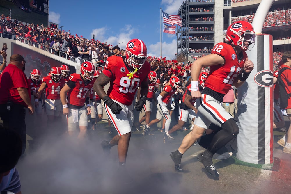 Georgia defensive lineman Elijah Griffin (left) and quarterback Ryan Puglisi run onto the field with teammates before their game against Charlotte at Sanford Stadium on Friday, Nov. 22, 2025, in Athens. (Jason Getz/AJC)