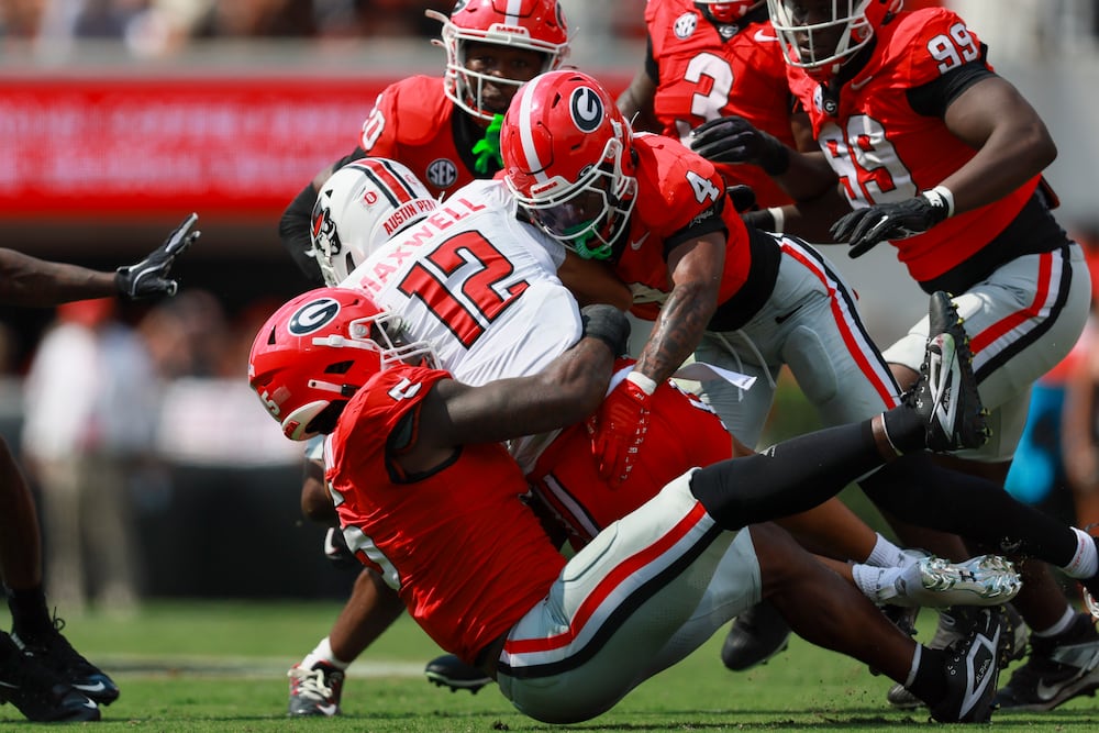 Georgia defensive back KJ Bolden (center right) and linebacker Raylen Wilson (left) tackle Austin Peay wide receiver Kamari Maxwell in September in Athens. (Jason Getz/AJC 2025)