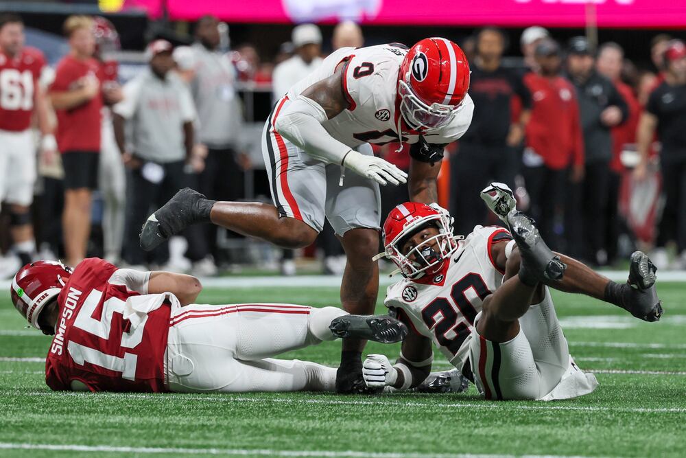 Georgia defensive back Jacorey Thomas (20) celebrates with Georgia linebacker Gabe Harris Jr. (0) after Thomas sacked Alabama quarterback Ty Simpson (15) for a nine-yard loss during the third quarter of the SEC Championship game at Mercedes-Benz Stadium, Saturday, Dec. 6, 2025, in Atlanta. Thomas had six tackles and a sack during Georgias 28-7 win over Alabama. (Jason Getz / AJC)