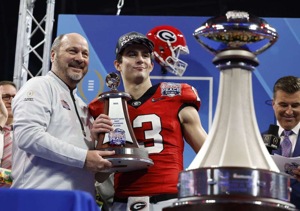 Georgia quarterback Stetson Bennett (center) and Gary Stokan, CEO and president of the Chick-fil-A Peach Bowl, after the College Football Playoff semifinal Dec, 31, 2022, in Atlanta. (Jason Parkhurst/Chick-fil-A Peach Bowl)