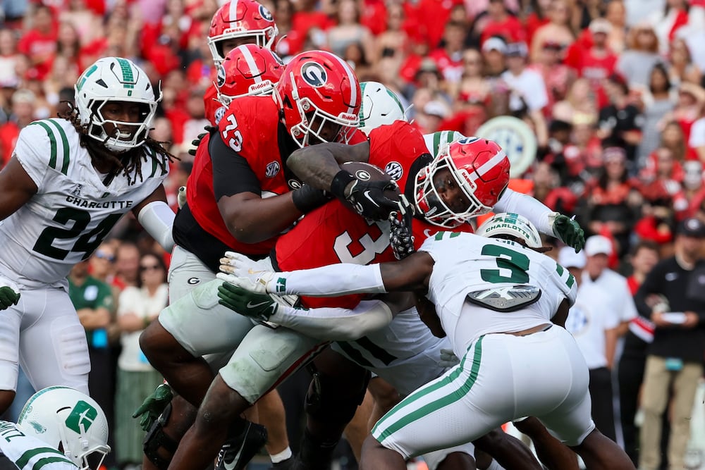 Georgia running back Nate Frazier (center) scores a touchdown, with help from offensive lineman Juan Gaston, against the Charlotte 49ers at Sanford Stadium on Friday, Nov. 22, 2025, in Athens. (Jason Getz/AJC)