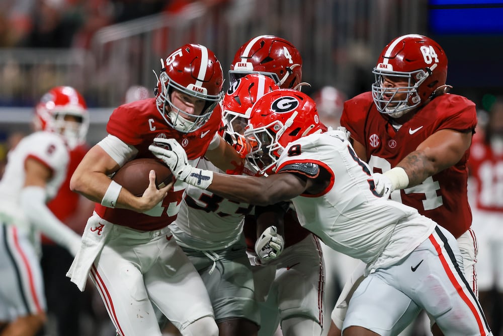 Georgia linebackers Chris Cole (right) and Quintavius Johnson tackle Alabama quarterback Ty Simpson (left) during the SEC championship game at Mercedes-Benz Stadium on Saturday, Dec. 6, 2025, in Atlanta. (Jason Getz/AJC)