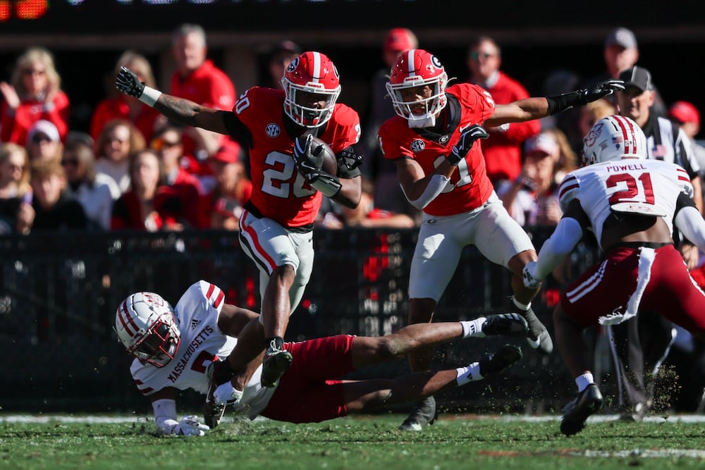 Georgia running back Dwight Phillips Jr. (left center) runs for yards against Massachusetts in November in Athens. (Jason Getz/AJC 2025)