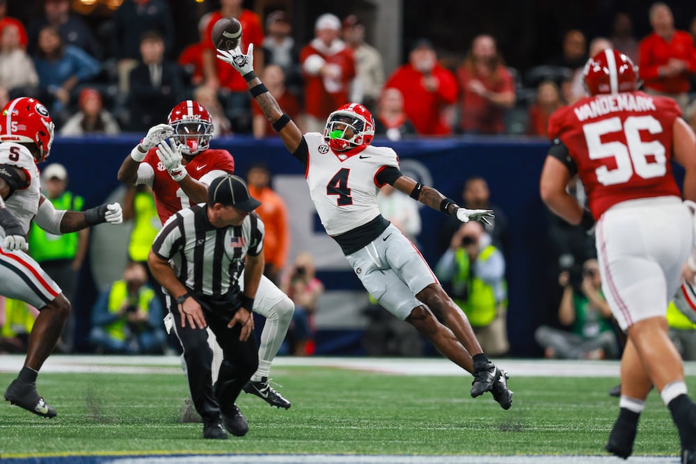 Georgia defensive back KJ Bolden (center) deflects a pass from Alabama quarterback Ty Simpson that was intercepted by teammate Daylen Everette during the SEC championship game at Mercedes-Benz Stadium on Saturday, Dec. 6, 2025, in Atlanta. (Jason Getz/AJC)