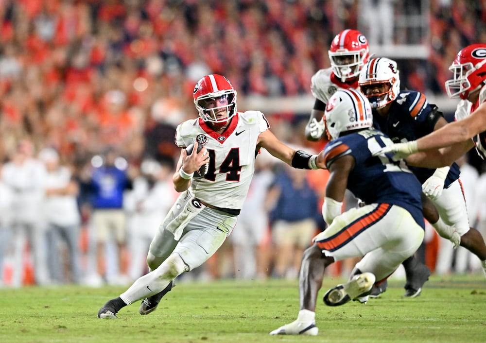 Georgia quarterback Gunner Stockton (left) runs the ball against the Tigers at Jordan-Hare Stadium on Saturday, Oct. 11, 2025, in Auburn, Ala. (Hyosub Shin/AJC)