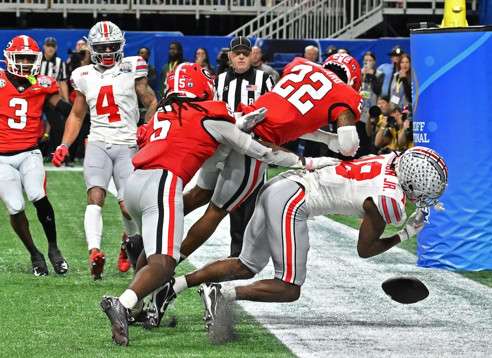 Ohio State wide receiver Marvin Harrison Jr. (right) gets hit by Georgia defensive back Javon Bullard during the Chick-fil-A Peach Bowl on Saturday, Dec. 31, 2022, in Atlanta. (Hyosub Shin/AJC)